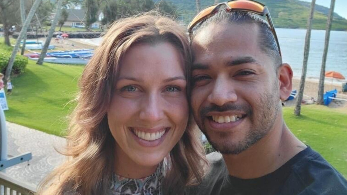 Shanna Gardner-Fernández y Mario Fernández sonríen en una foto en la playa.