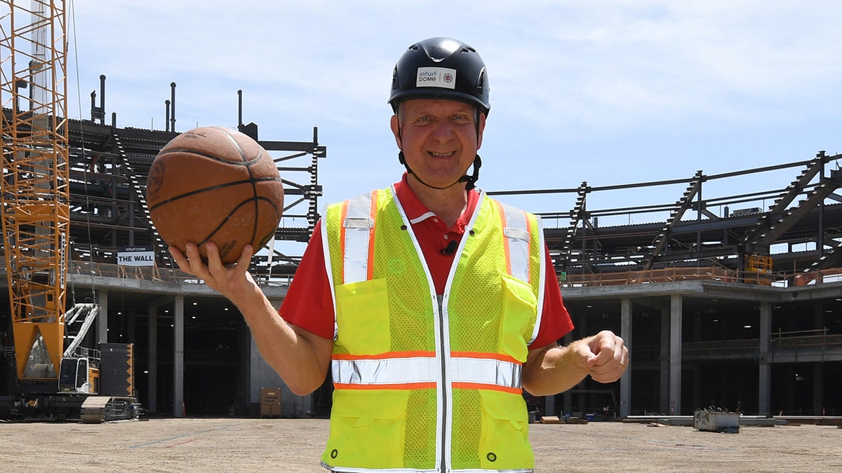 Steve Ballmer holds ball at construction site