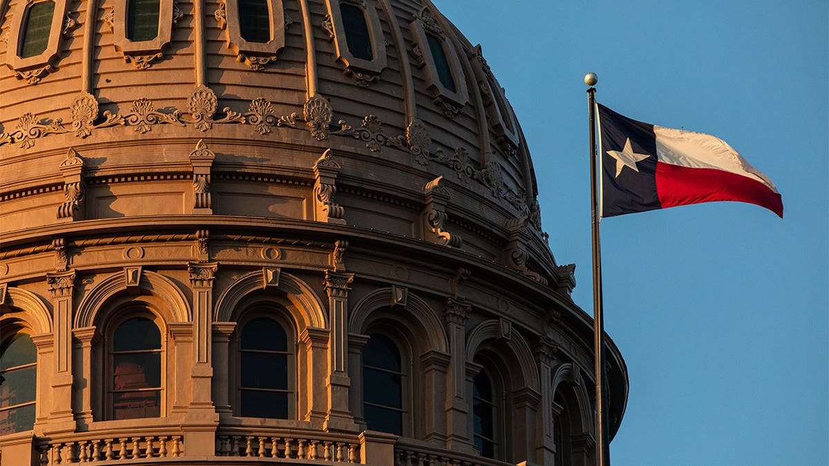 Texas Capitol building dome with the Texas flag waving in front