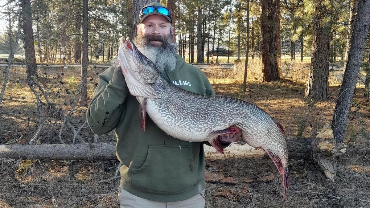 Idaho man Thomas Francis holds record-breaking northern pike while on land