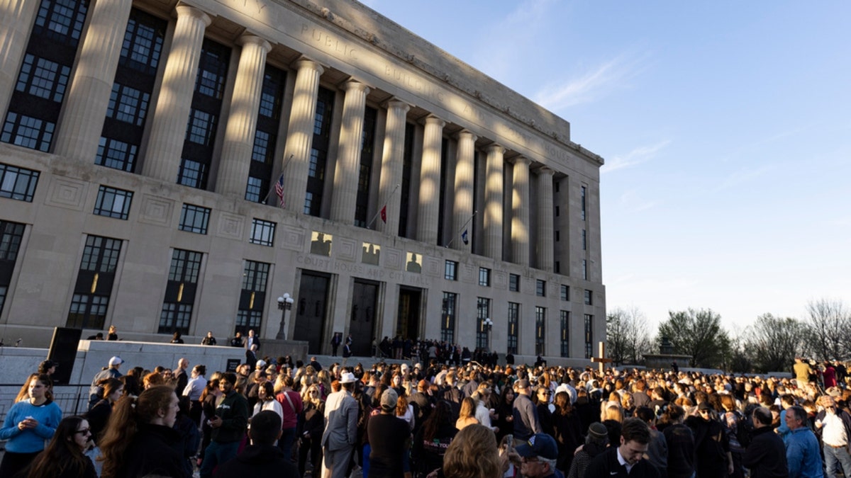 A crowd gathers outside the courthouse and City Hall for a vigil