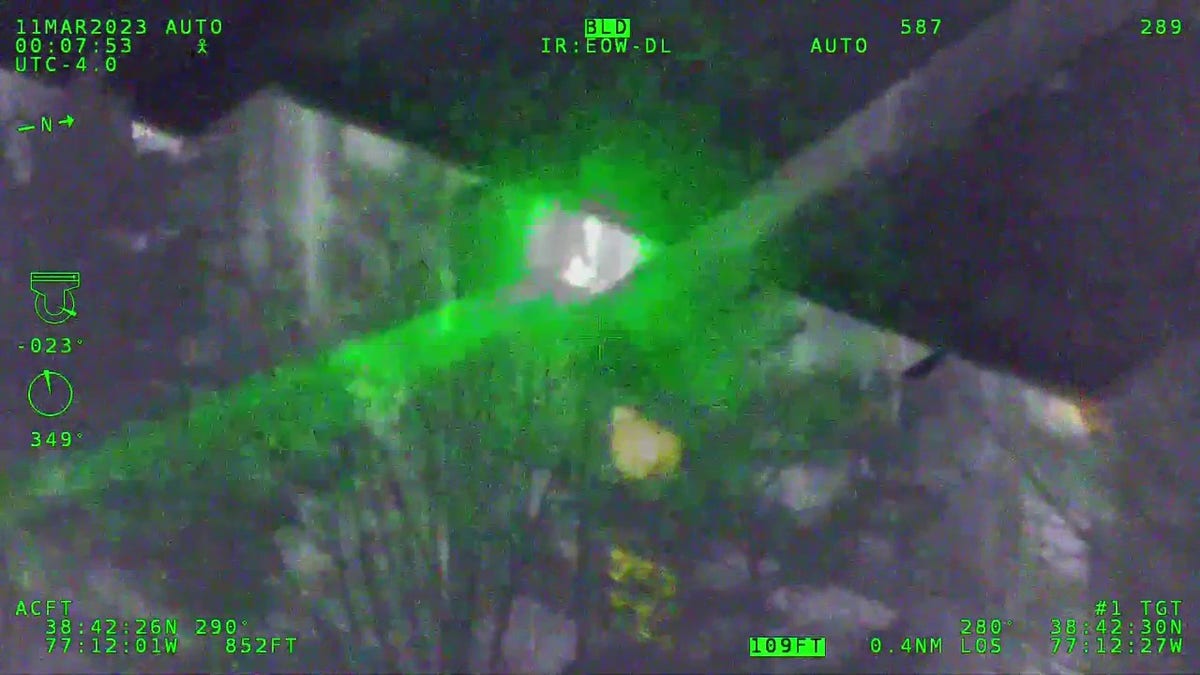 Man shining laser at helicopter