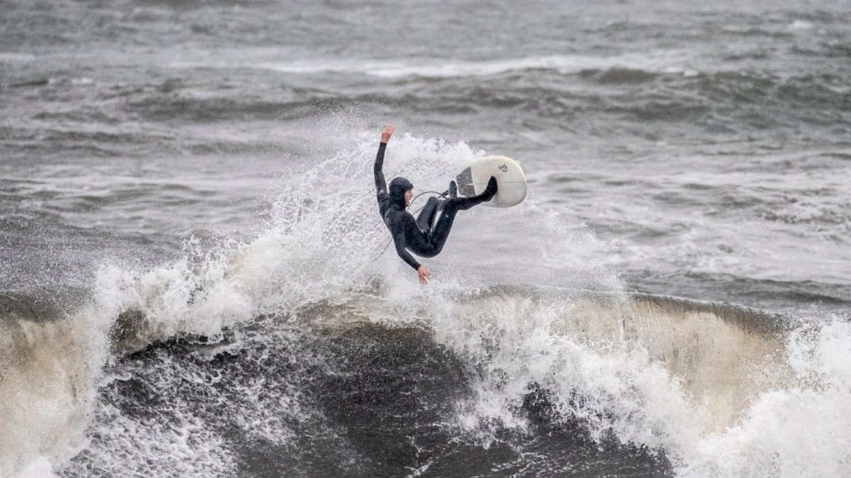 A surfer rides choppy waves at Cowell Beach