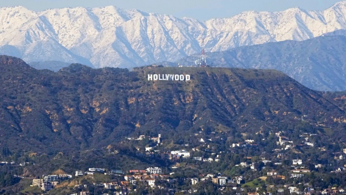 The Hollywood sign in front of mountains with snow on them
