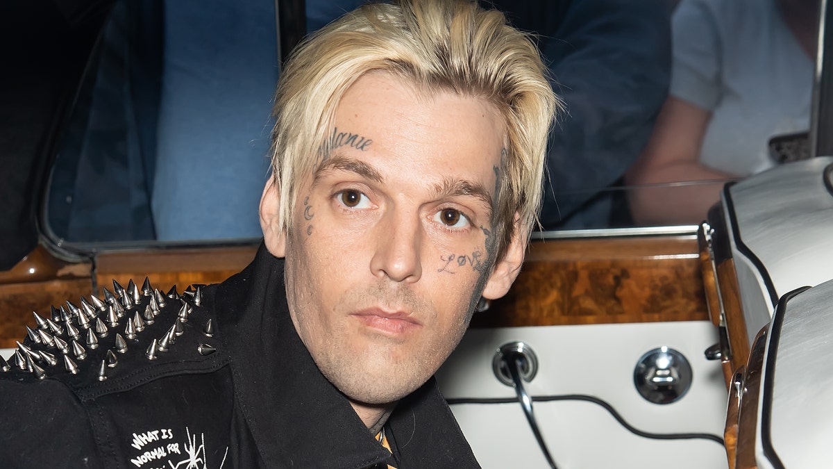 Aaron Carter looks somber with multiple face tattoos.
