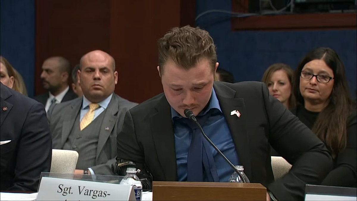 Marine Sgt. Tyler Vargas-Andrews speaking into microphone at congressional hearing