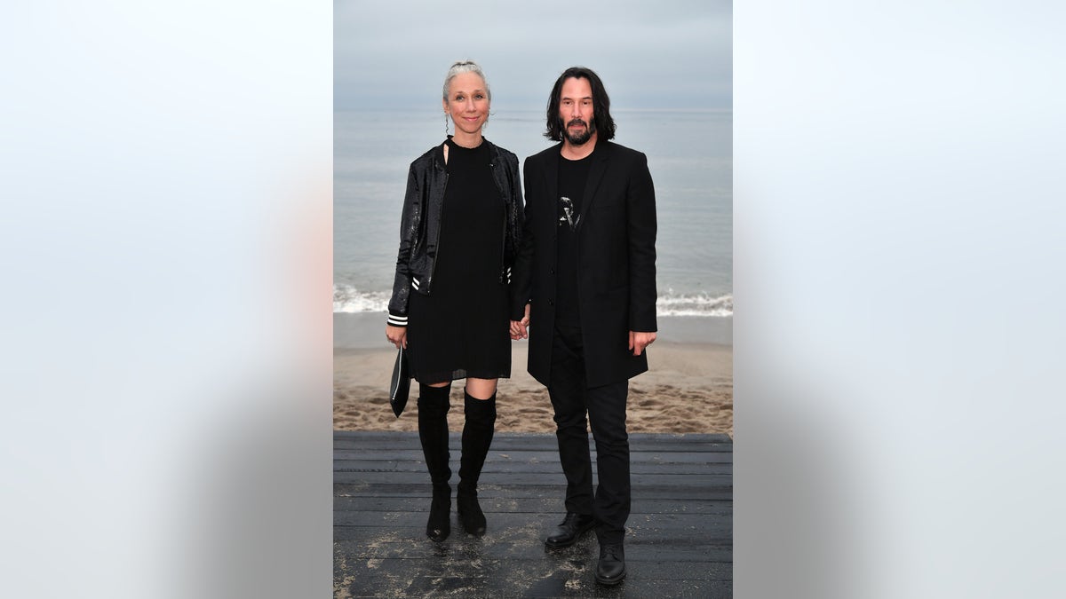 Keanu Reeves with Alexandra Grant on a beach