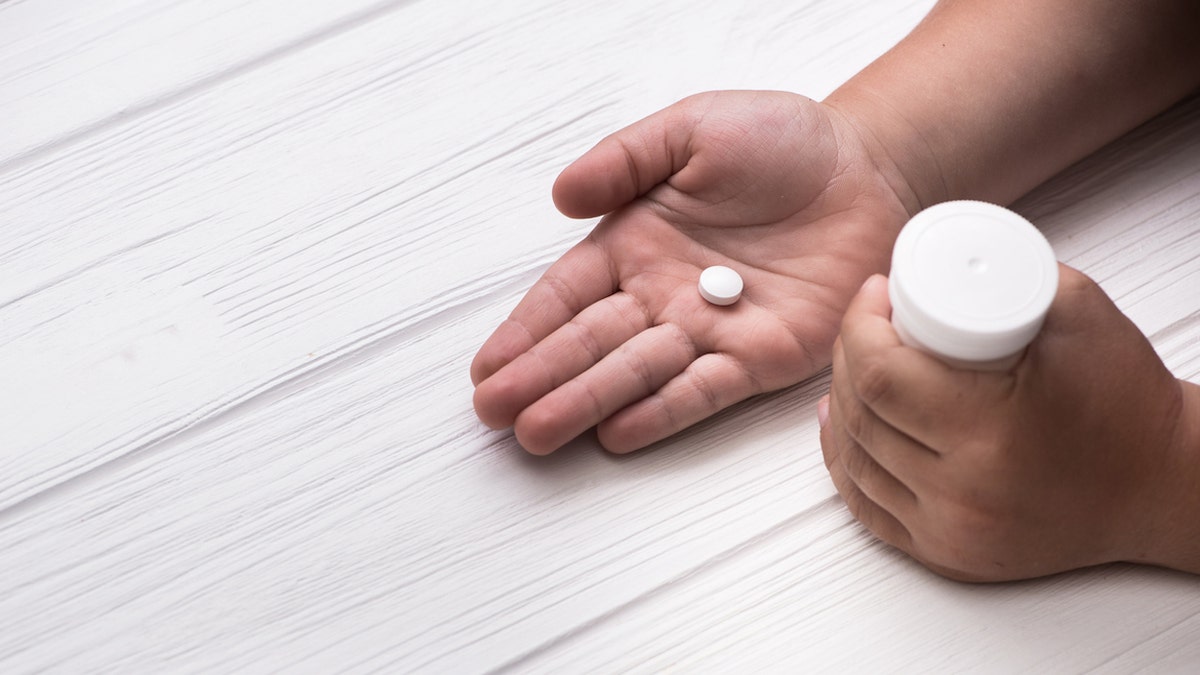 Baby holding pill