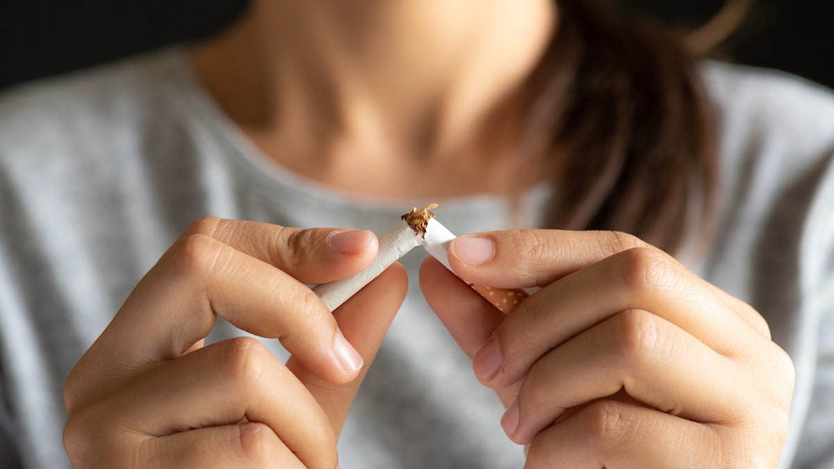 woman breaking cigarette