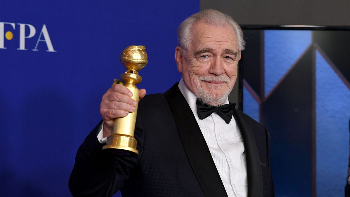 Brian Cox holding a Golden Globe