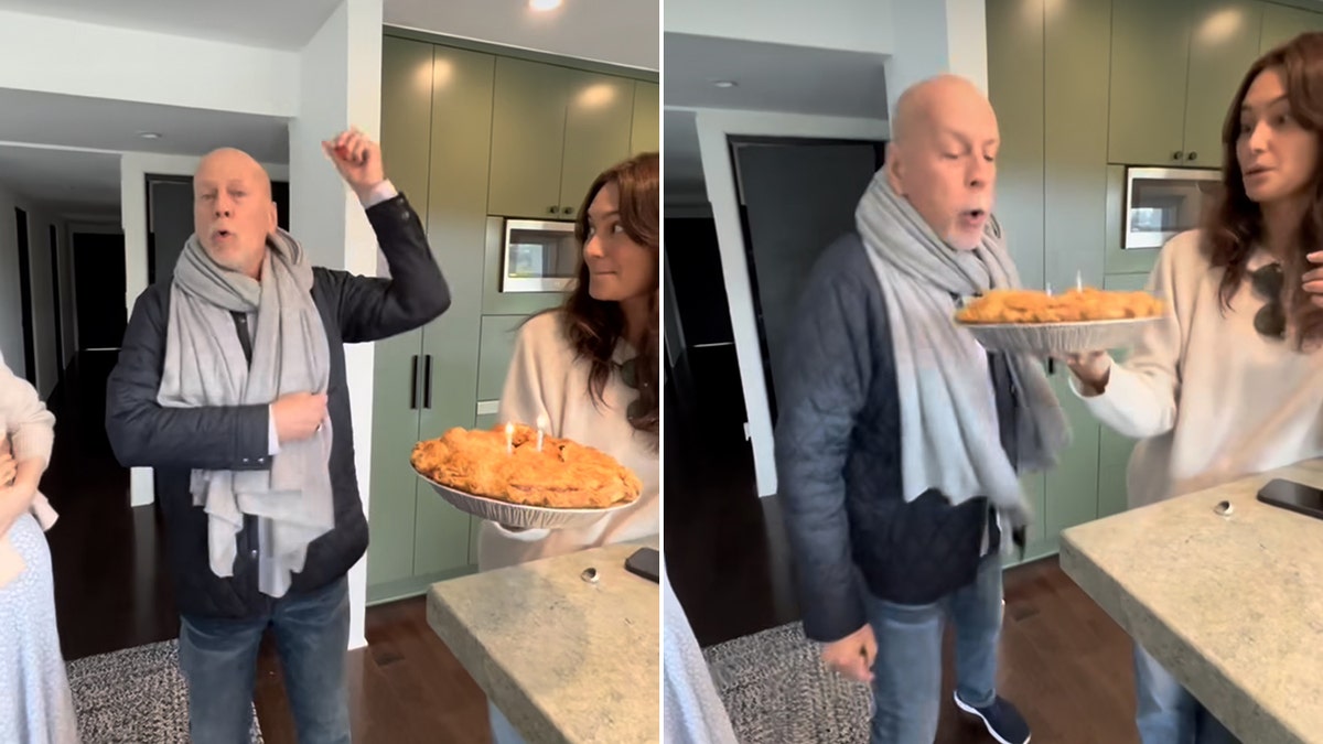 Bruce Willis throws his arms in the air as he is presented with an apple pie for his birthday by wife Emma split Willis blows out the candles in his pie