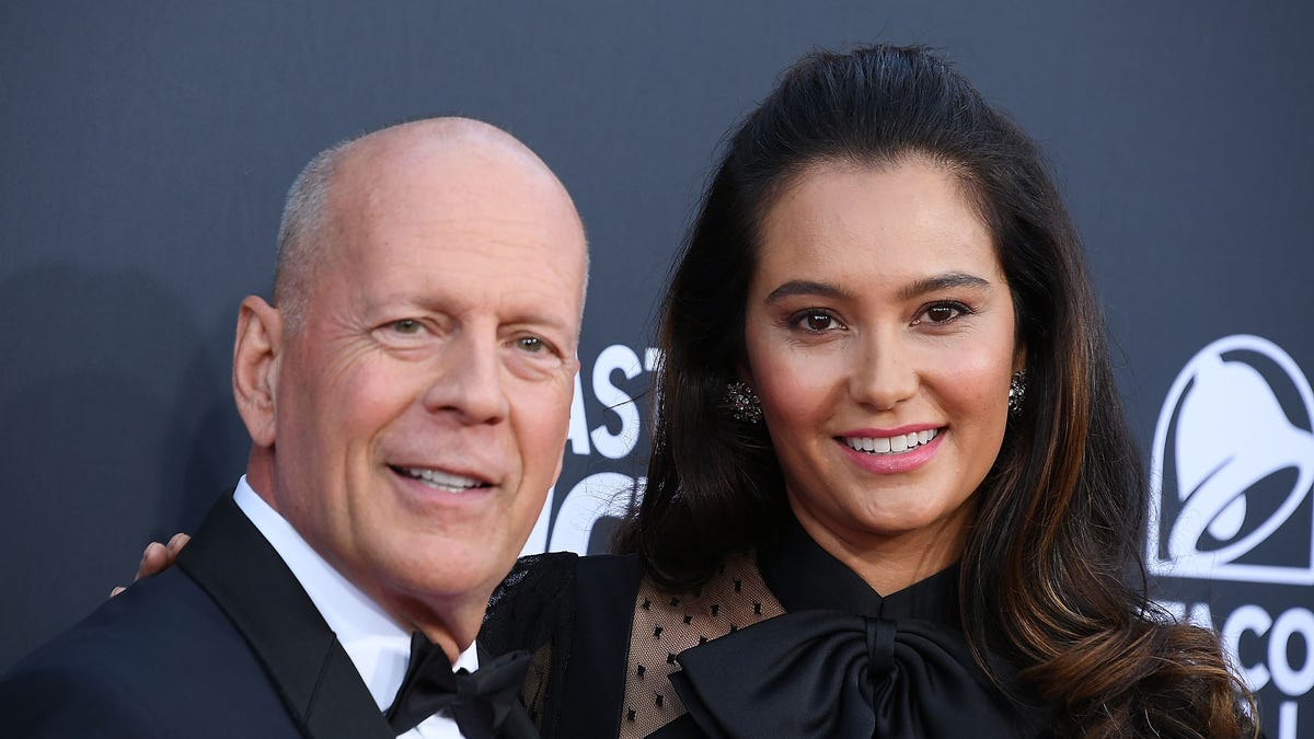 Bruce Willis poses with wife Emma Heming Willis on a red carpet.