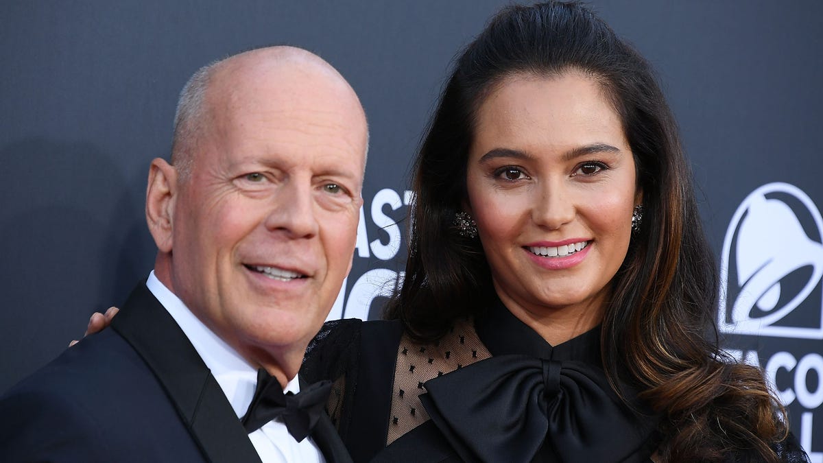 Bruce Willis poses with wife Emma Heming Willis on a red carpet.