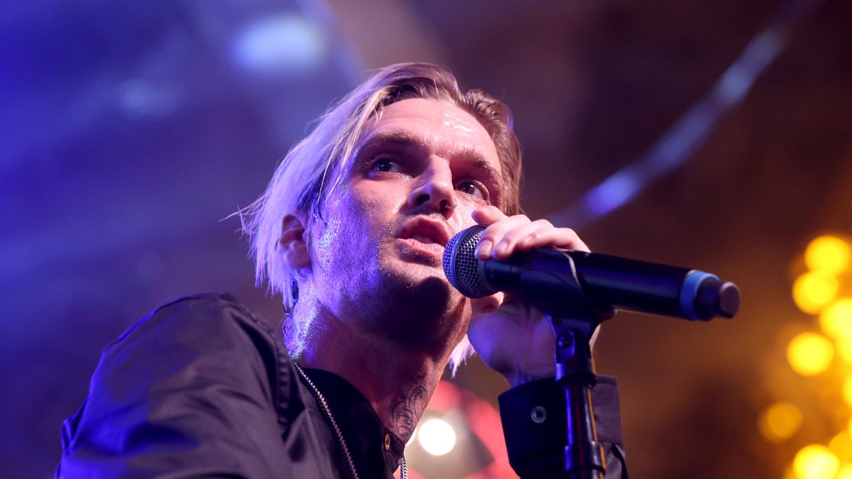 Aaron Carter sings into a microphone at a concert
