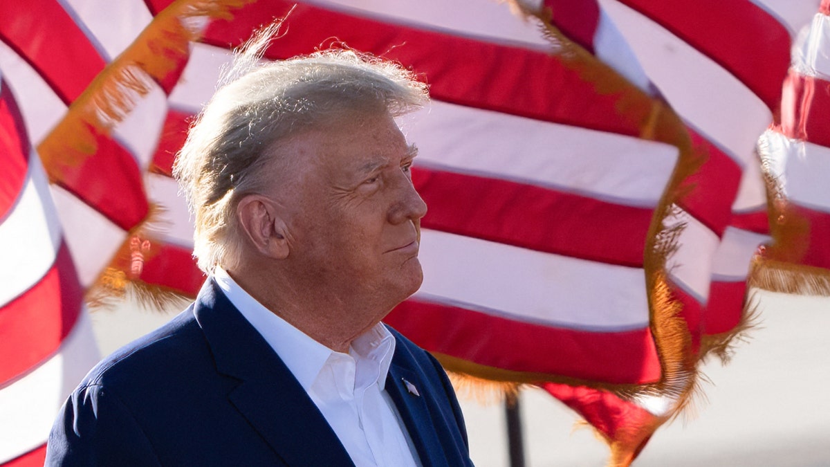 Former U.S. President Donald Trump with American flags in the background