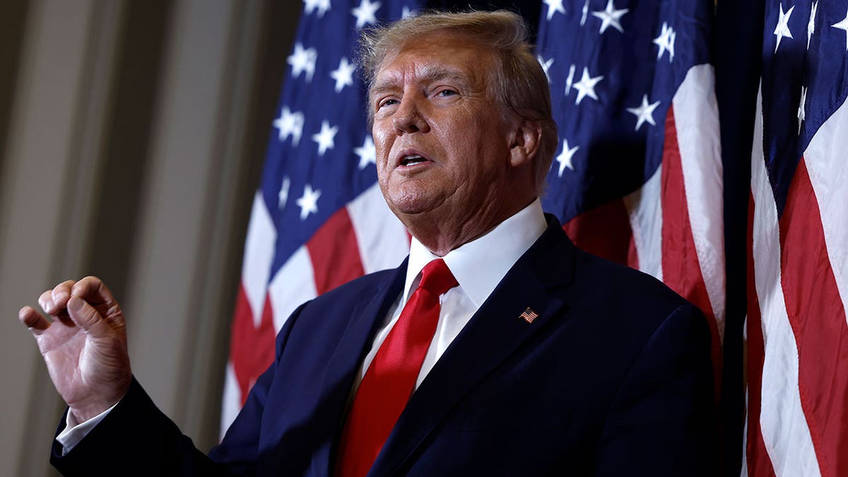 Former President Donald Trump stands in front of American flag