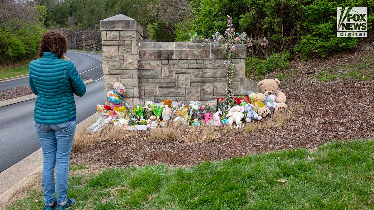 A mourner visits a memorial outside of The Covenant School