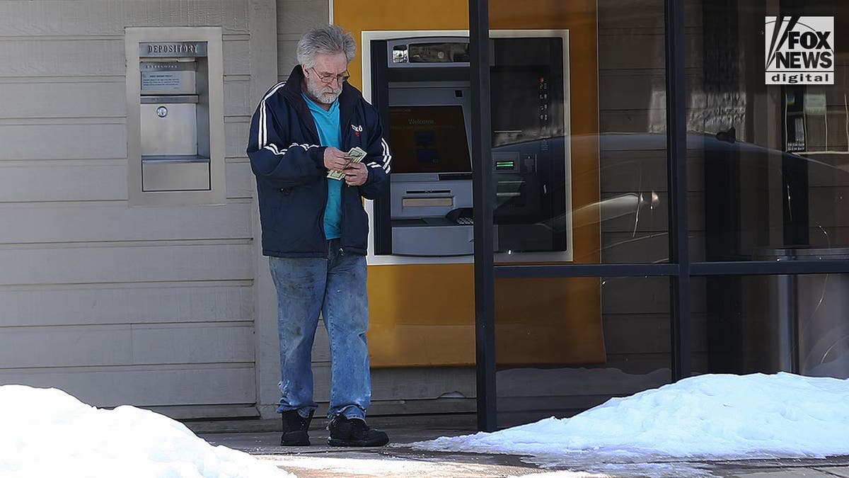 Eddie Tubbs is dressed in jeans and a jacket as he leaves an ATM