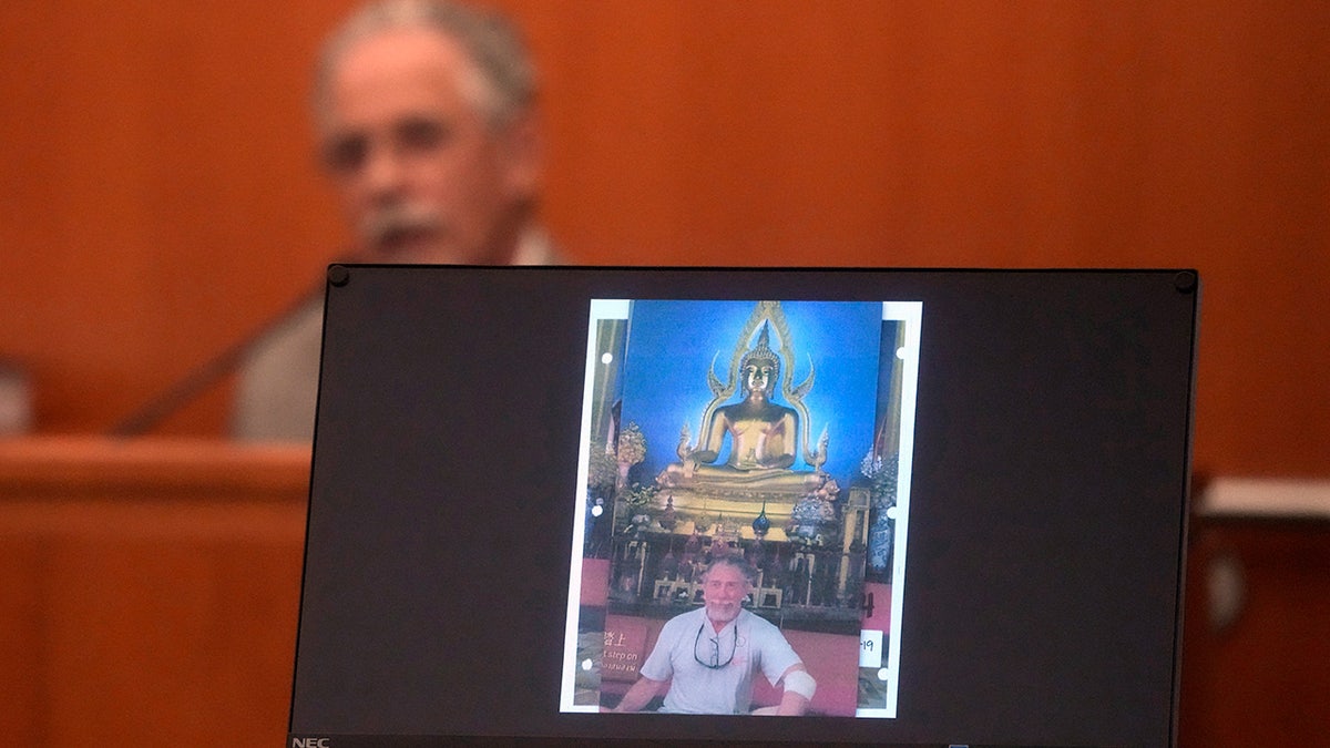 Terry Sanderson stands in front of a temple on a trip after ski collision.