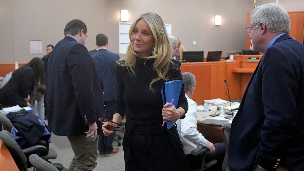 Gwyneth Paltrow leaves court Wednesday wearing black dress and carrying blue notebook