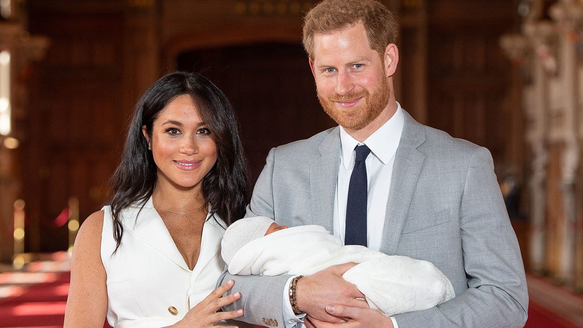 Harry and Meghan holding Archie as a baby