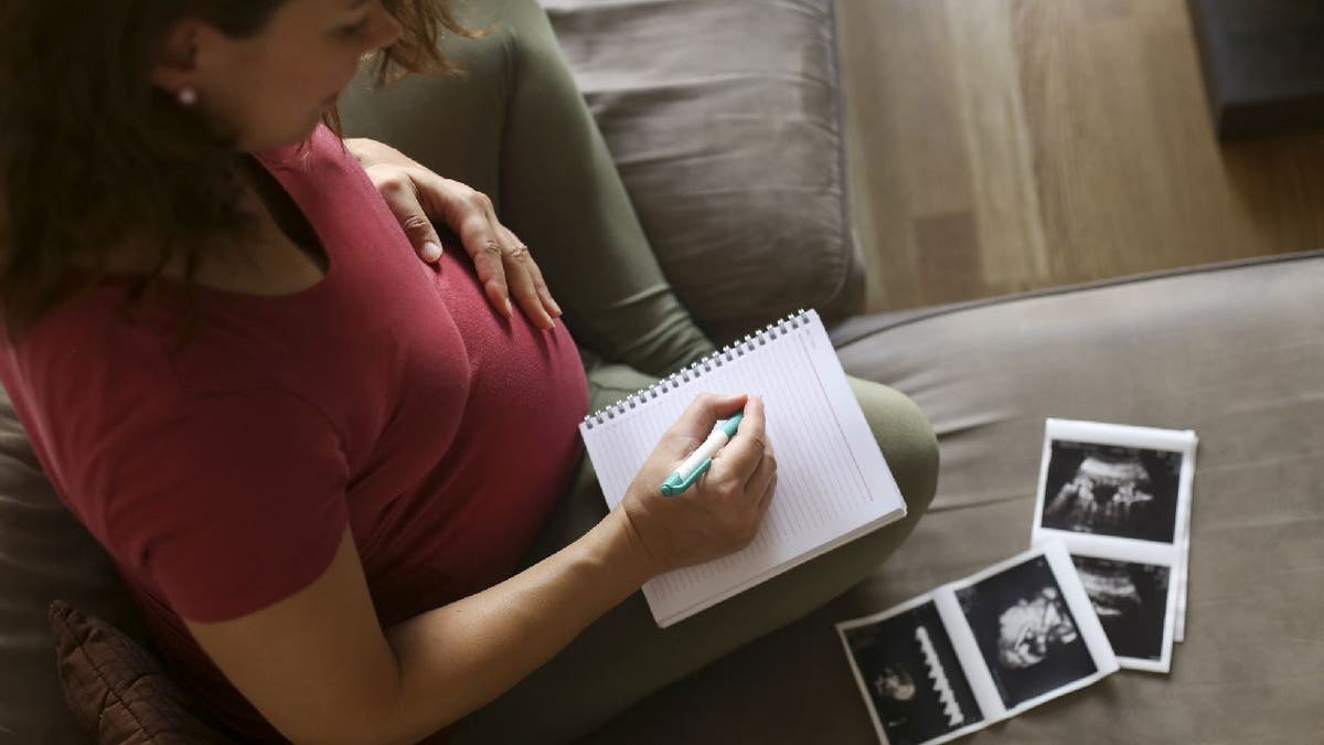 Pregnant mother tries to write down baby names