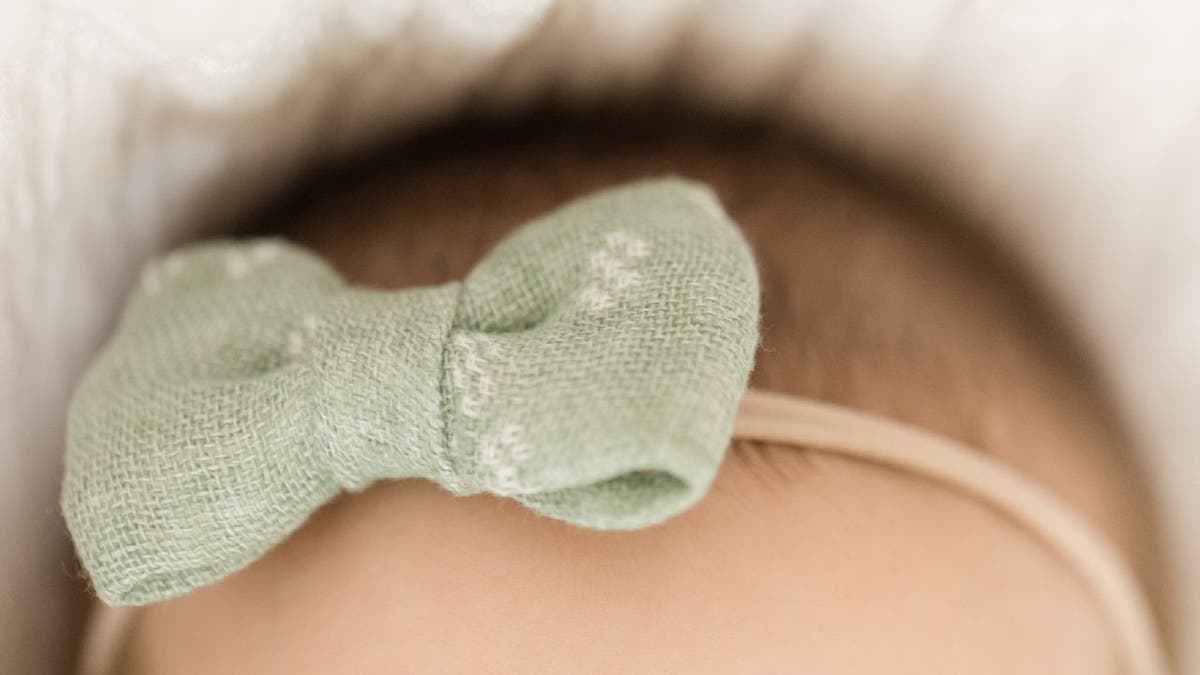 Baby girl with green hair bow