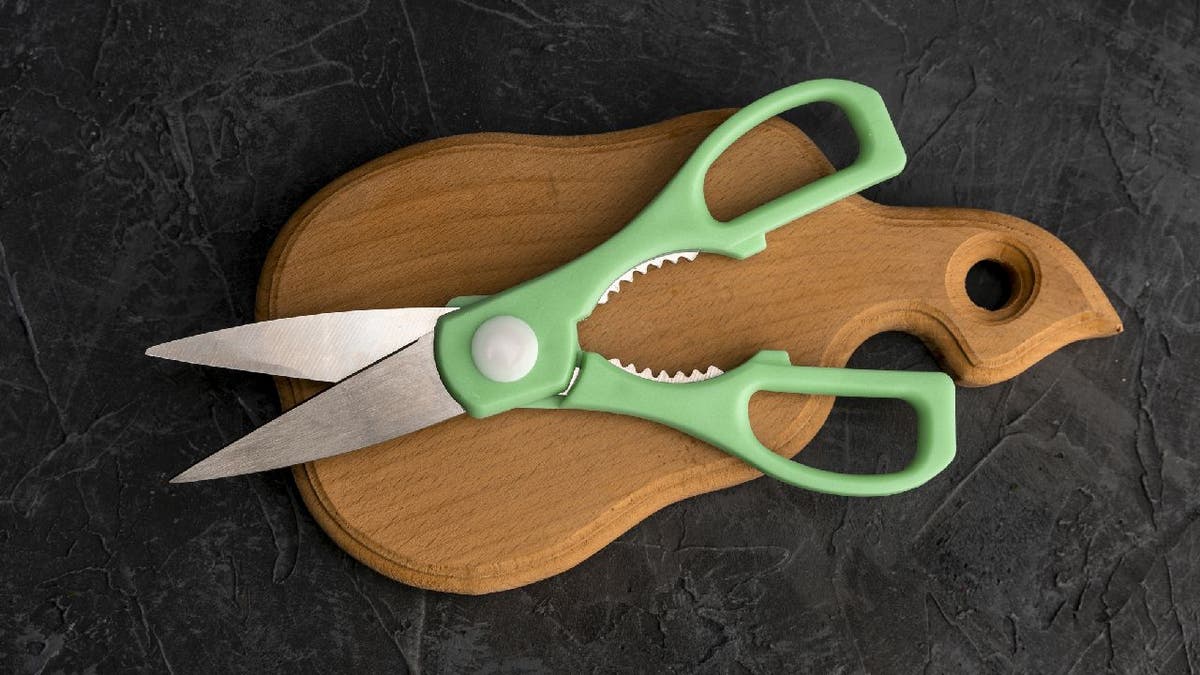 Close-up image of kitchen shears on a wooden cutting board