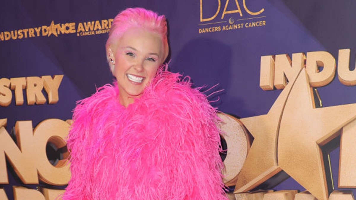 jojo siwa with pink hair and pink feather outfit on red carpet
