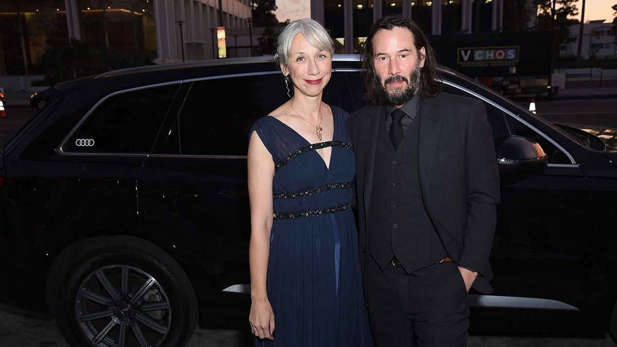 Keanu Reeves posting with Alexandra at event