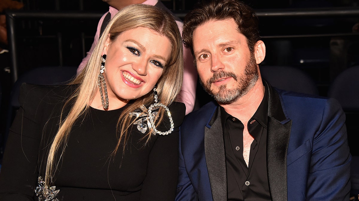 Kelly Clarkson and Brandon Blackstock pose at an event together.