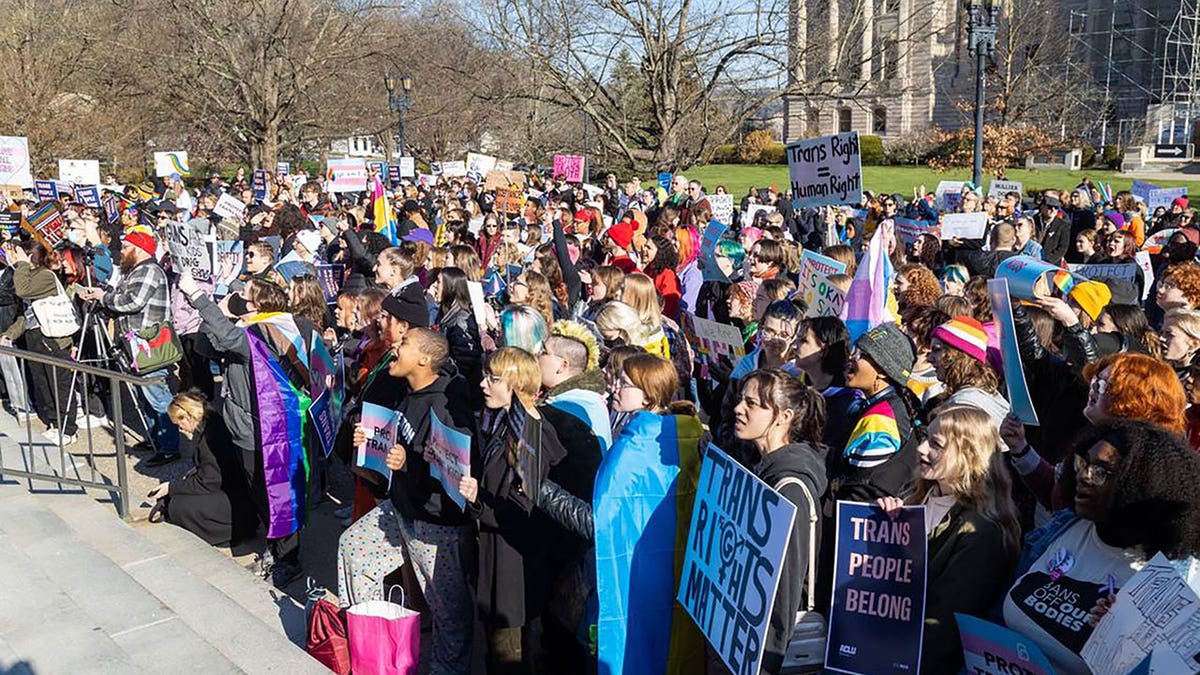 Protesters hold signs outside of the Kentucky Capitol building