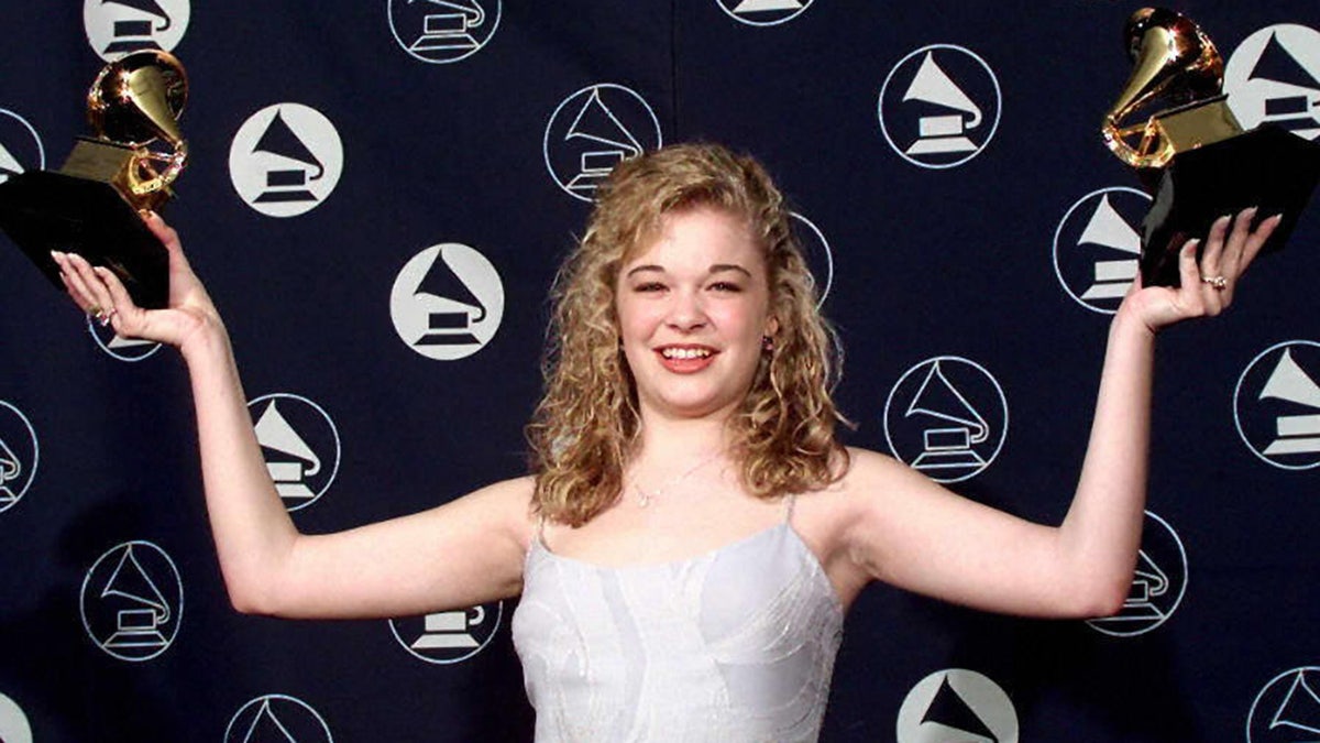 LeAnn Rimes holds up Grammy Awards in 1997