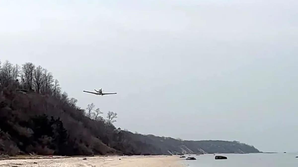 small plane flying low over beach