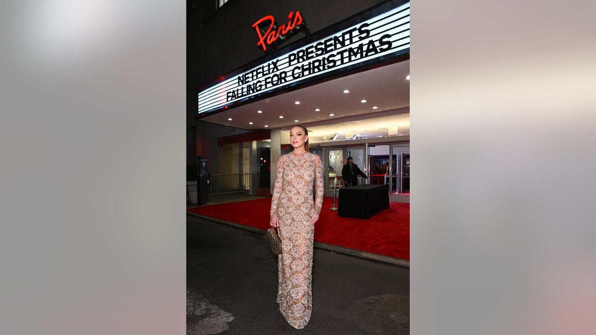 Lindsay Lohan in front of the "Falling for Christmas" marquee 