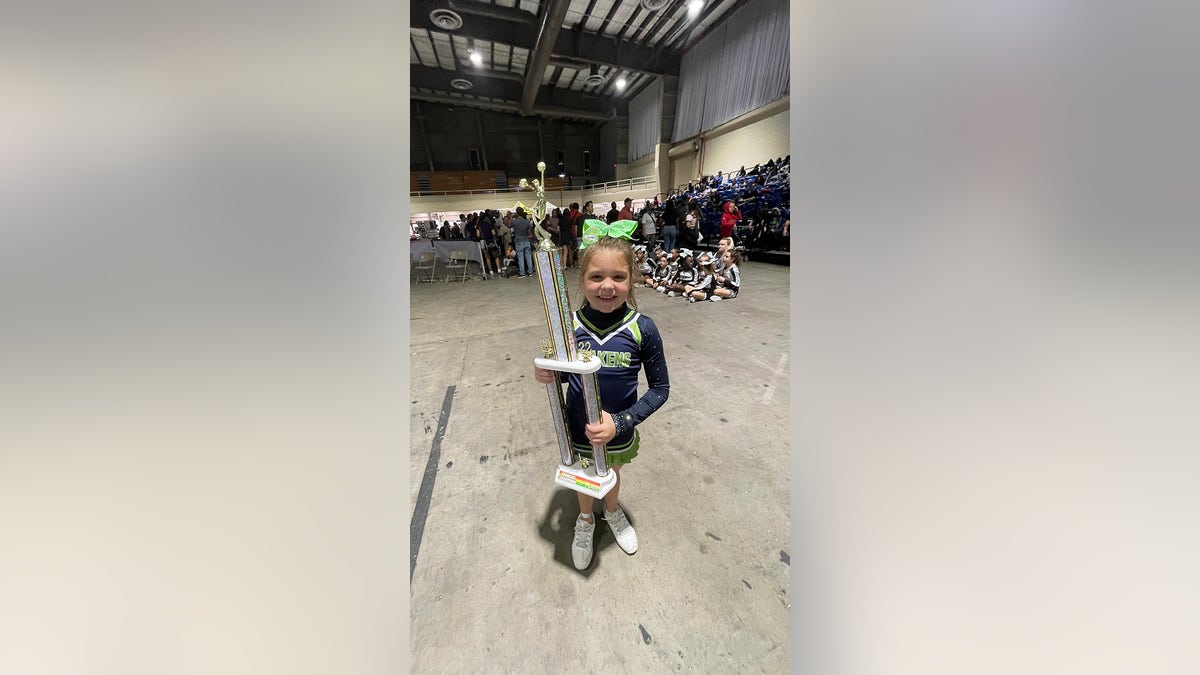 With a big smile on her face, Peyton Thorsby shows off the first-place trophy she earned when she competed solo at a cheer competition.