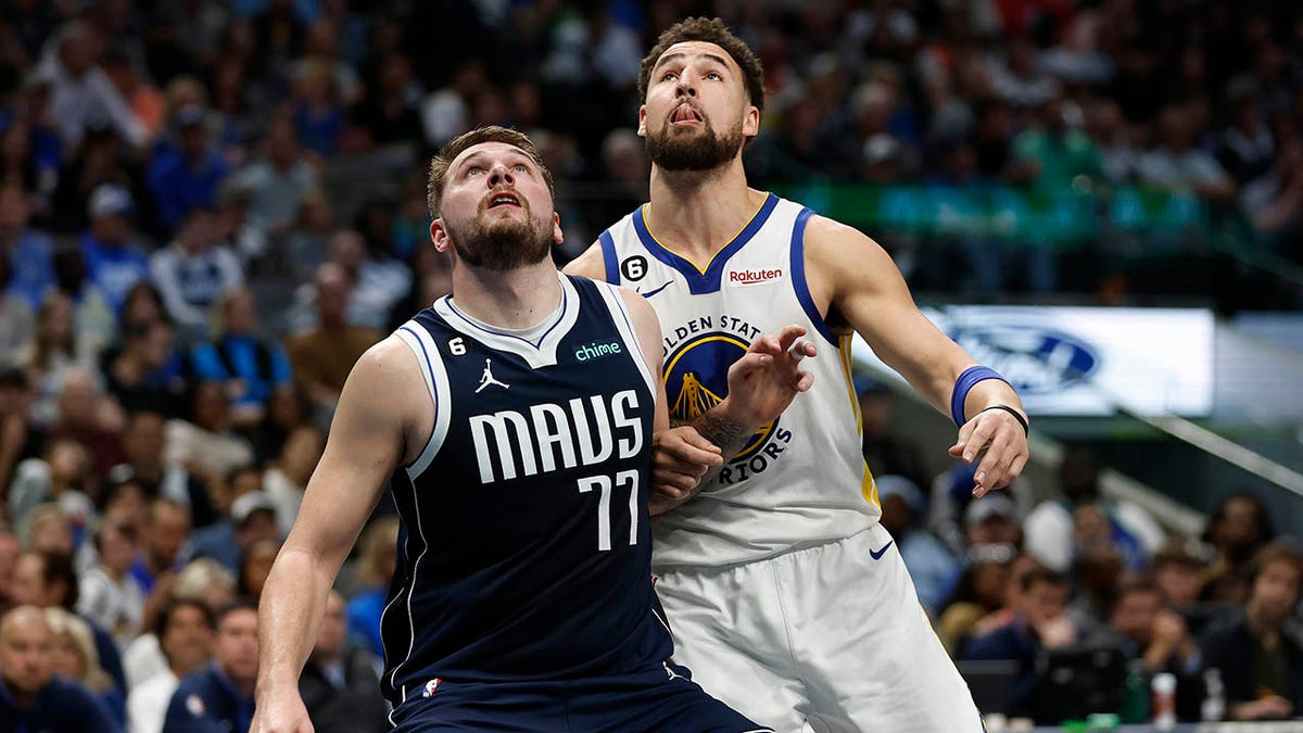 A Mavs player and a Golden State player on the court