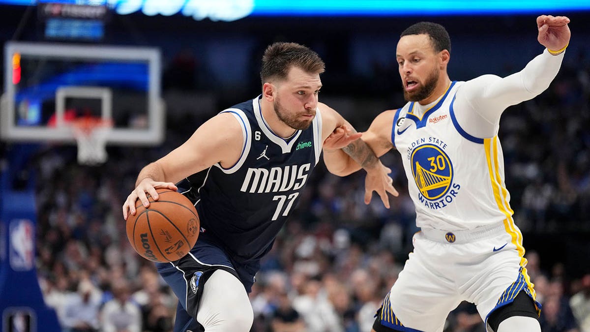 Luka dribbles as Steph Curry guards him