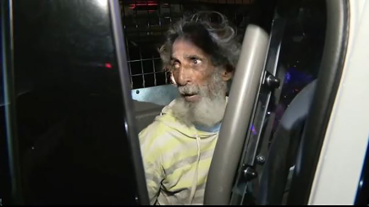 man sitting in back of police car