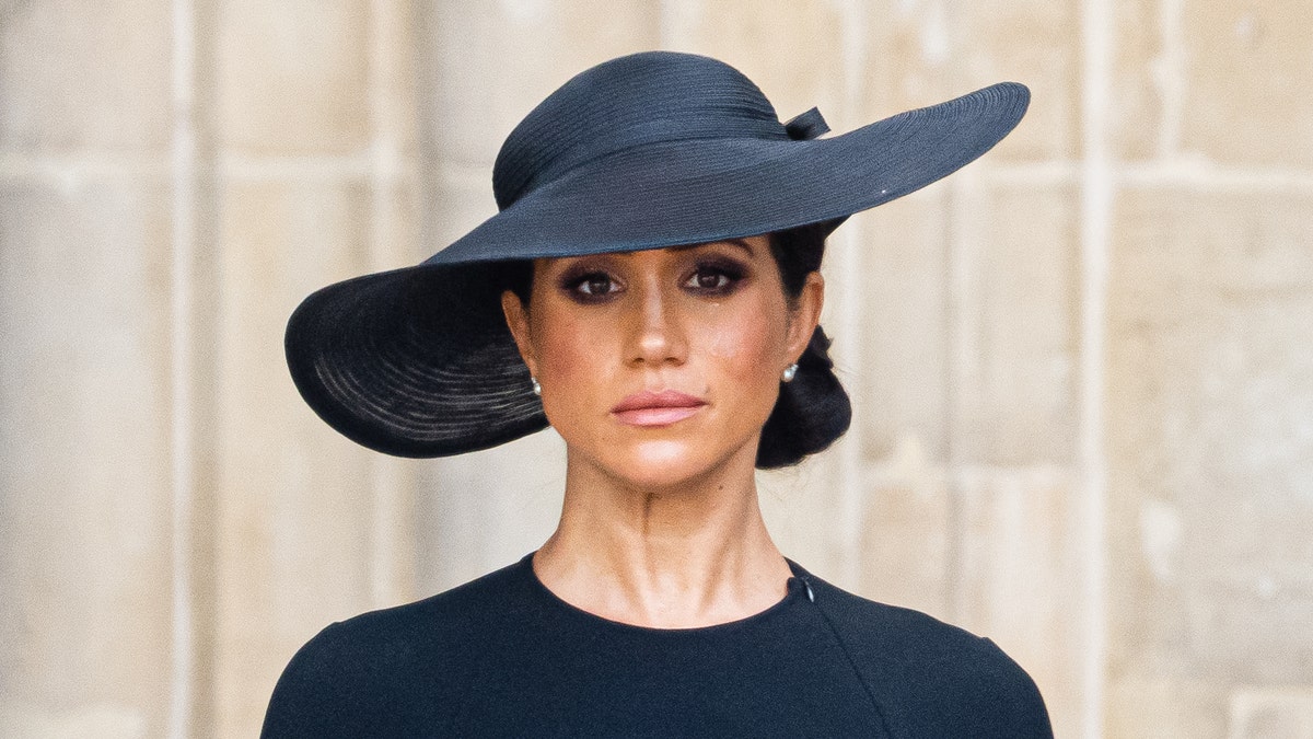 Meghan Markle wears a achromatic dress and a achromatic chapeau astatine Queen Elizabeths funeral.