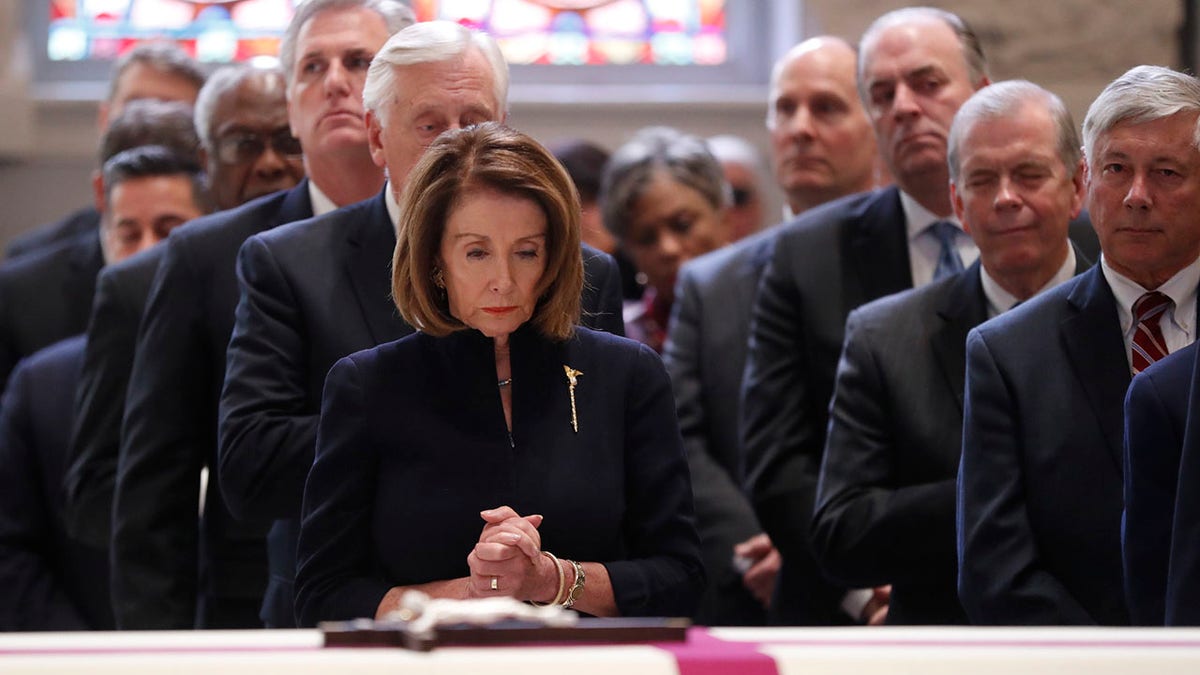 Nancy Pelosi praying