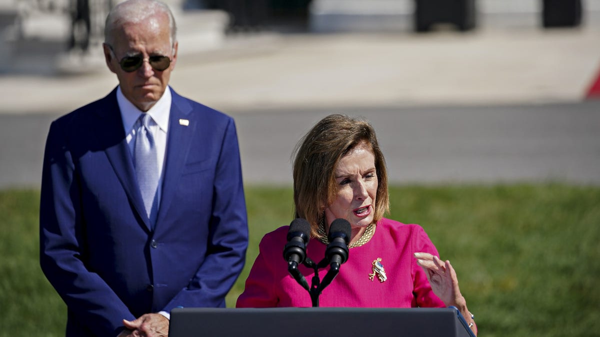 US House Speaker Nancy Pelosi, a Democrat from California, speaks as US President Joe Biden left, listens during a signing ceremony for H.R. 4346, the Chips and Science Act of 2022, on the South Lawn of the White House in Washington, D.C., US, on Tuesday, Aug. 9, 2022