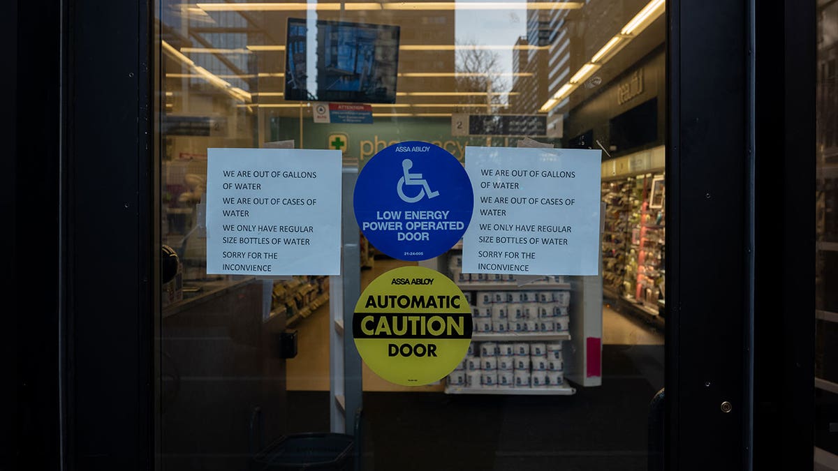 Signs on a grocery store saying no more water available