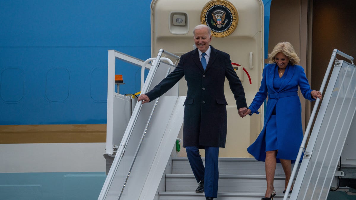 U.S. President Joe Biden (L) walks down the stairs of Air Force One with First Lady Jill Biden (R) after arriving in Canada
