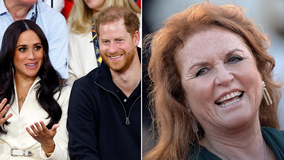 Meghan Markle in a white suit and silver buckle has her hands up in the air sitting next to Prince Harry in black split Duchess of York Sarah Ferguson laughs and looks to her right in a green dress