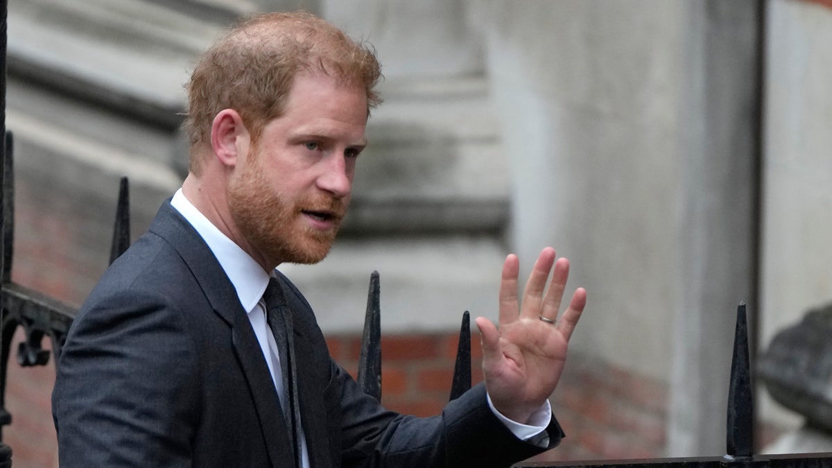 Prince Harry waves as he shows up to court.
