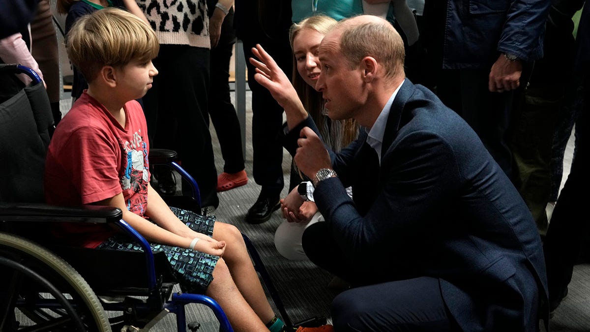 Prince William speaks a boy in a wheelchair 