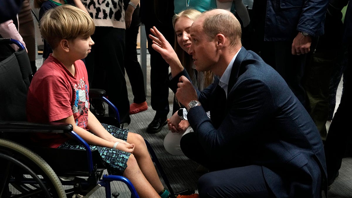 Prince William speaks a boy in a wheelchair