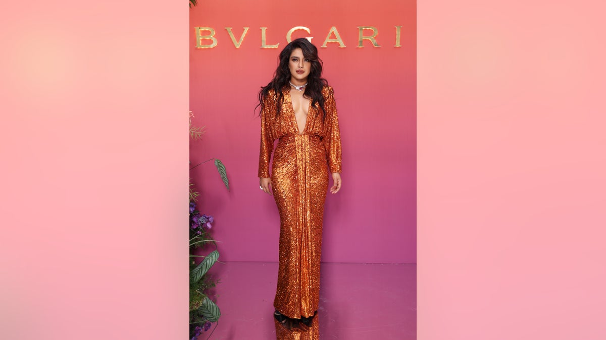 Priyanka Chopra is an orange dress with plunging neckline
