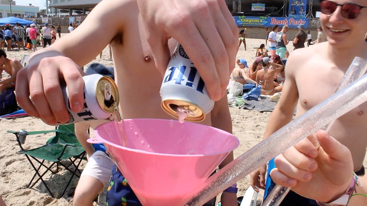 College boys fill up a pink beer funnel with Miller Lite.
